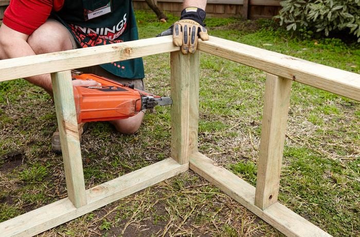 Supports for the roosting box being nailed together by a Bunnings team member with a nail gun