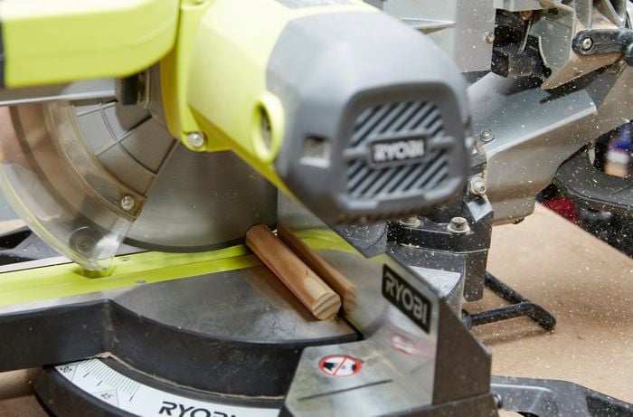 Dowel being cut using a drop saw