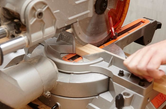 Person using circular saw to cut up timber.
