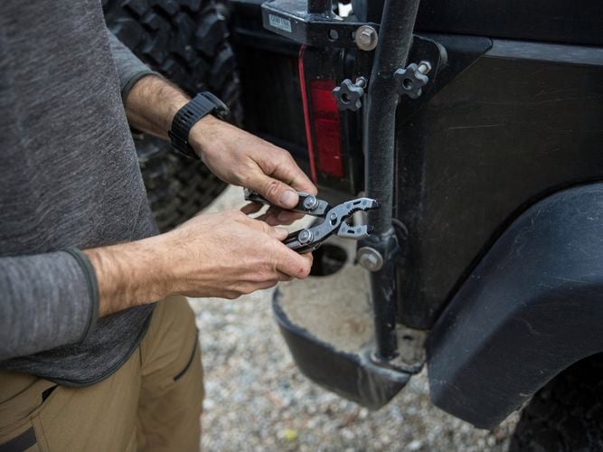 A person holding a dual force multi tool with his hands.