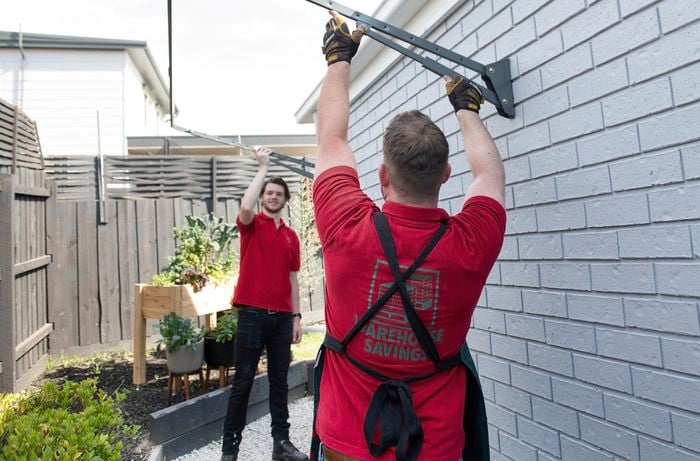 Two people attaching front bar to side arms