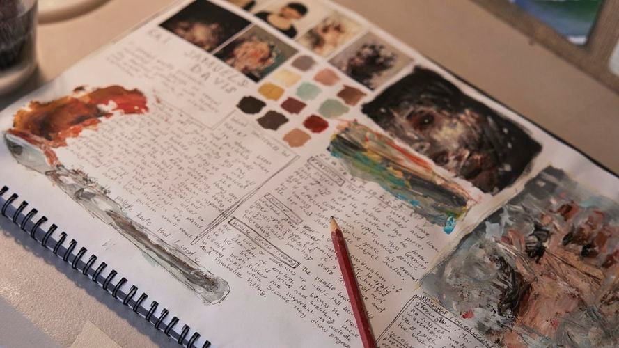 Painting journal on desk with painting inspiration and notes