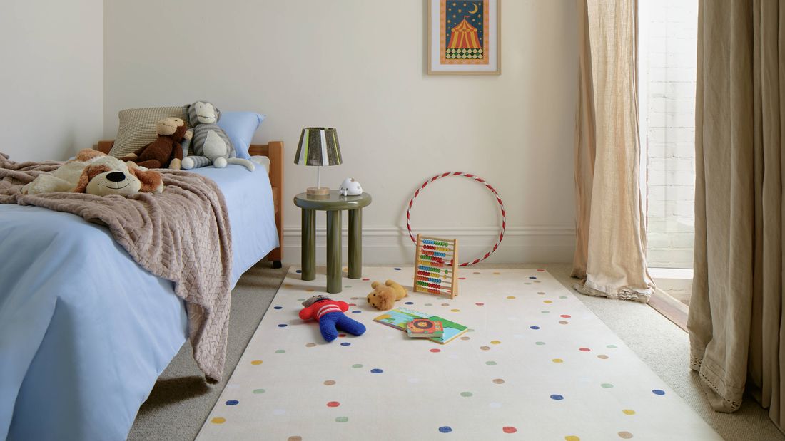 Child’s bedroom with bed, toys on rug, and soft natural light