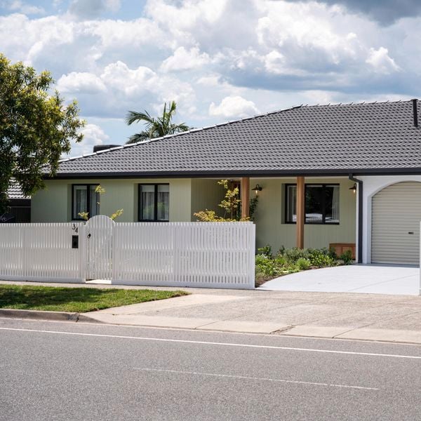 Front of house with a picket fence at the front of it