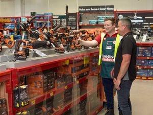Bunnings team member assisting a customer in the power tool isle.