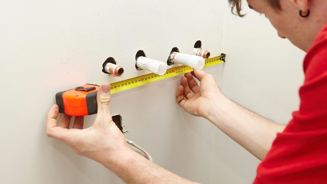 A Bunnings team member measuring the position of the water pipes.