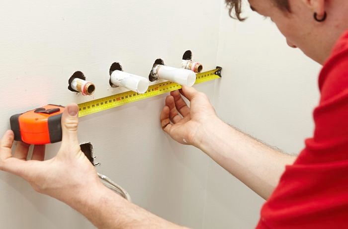 A Bunnings team member measuring the position of the water pipes.