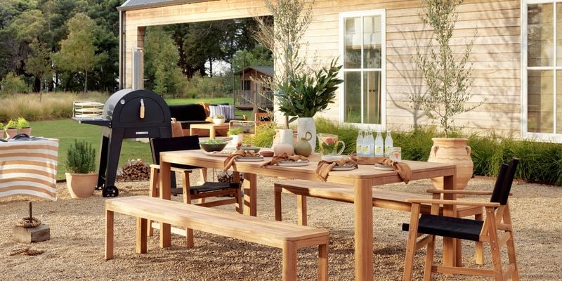 Outdoor timber setting with a BBQ and some pot plants.