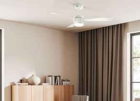 A white Rosedale ceiling fan with a light is installed in a modern room with large windows, curtains and a wooden cabinet.]    Caption: Choose the right Hunter ceiling fan for your home to make staying cool a breeze. 