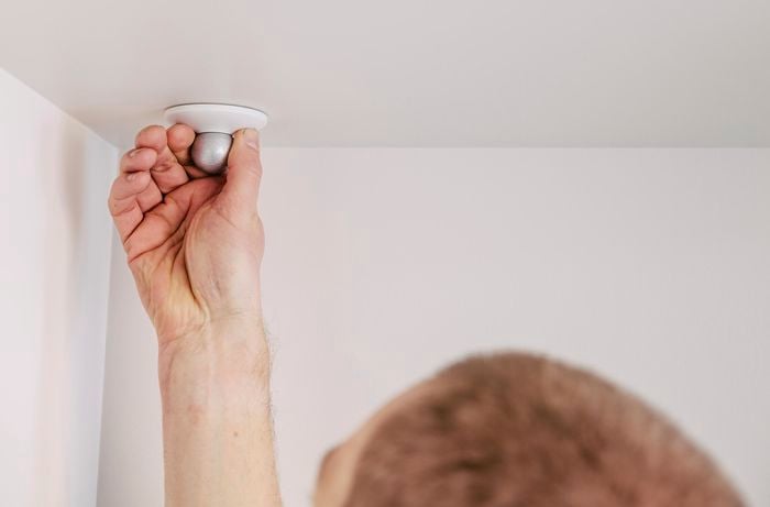 Close up of a security camera base being screwed into place on a ceiling
