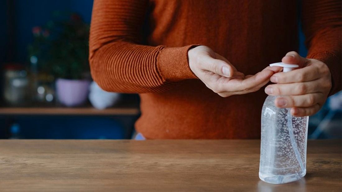 A person dispensing hand sanitiser into their hands
