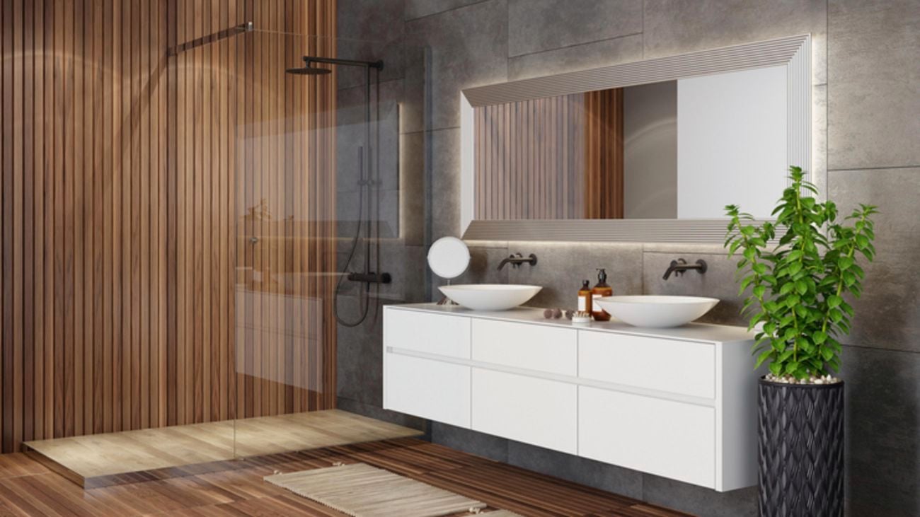 A modern bathroom with floating vanity and waterfall shower separated by a glass screen.