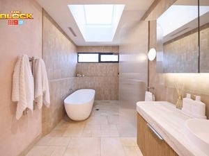 Natural coloured bathroom with a timber fluted profile vanity and marble benchtop and bath