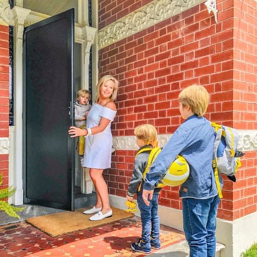 Family entering a house through the front security door