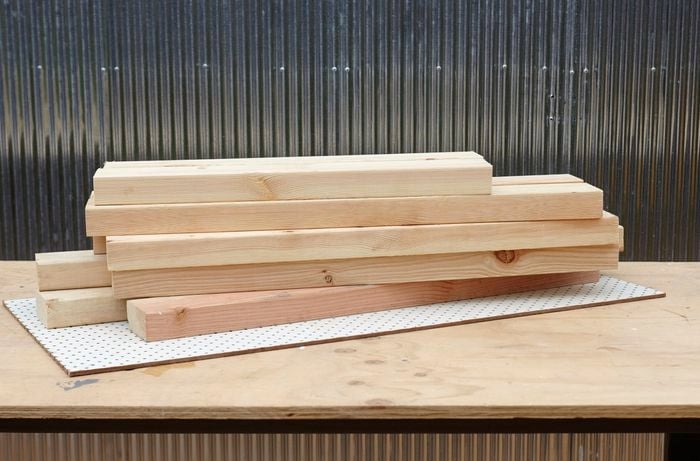Cut lengths of pine framing timber and a sheet of pegboard
