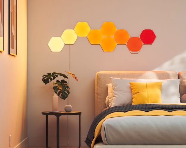 9 smart light panel layout mounted onto a wall behind a bed frame.