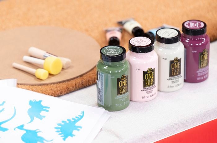 Prepare your workspace with paint bottles, sponge brushes,and a coir mat