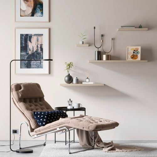 Floating shelves on a wall with wall prints, chair and lamp.