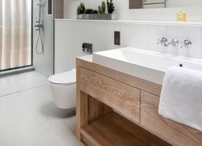 Modern bathroom with wood vanity, grey tiling and silver tapware.