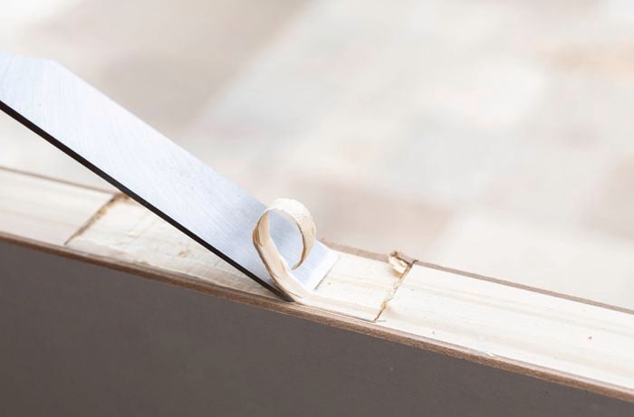 A chisel is used to form clean hinge recesses in the door frame, allowing the door to sit evenly and operate smoothly. 