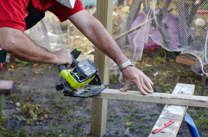 Person sawing bit of timber.