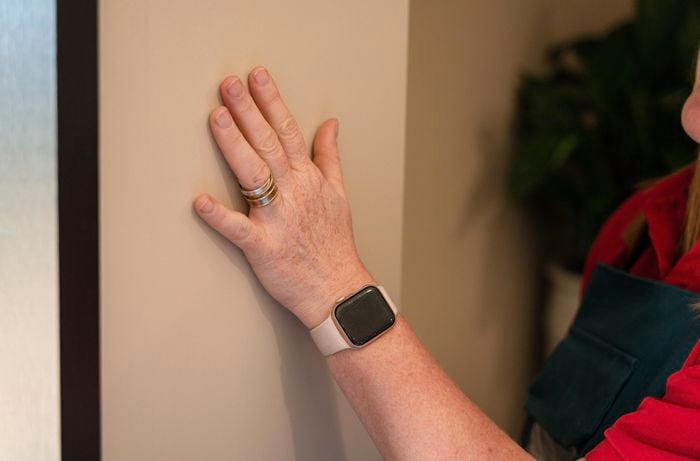 A person keeping his hand on the wall.