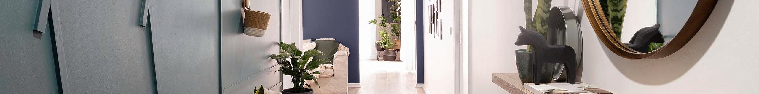 Living room with large couch, coffee table and indoor plants.