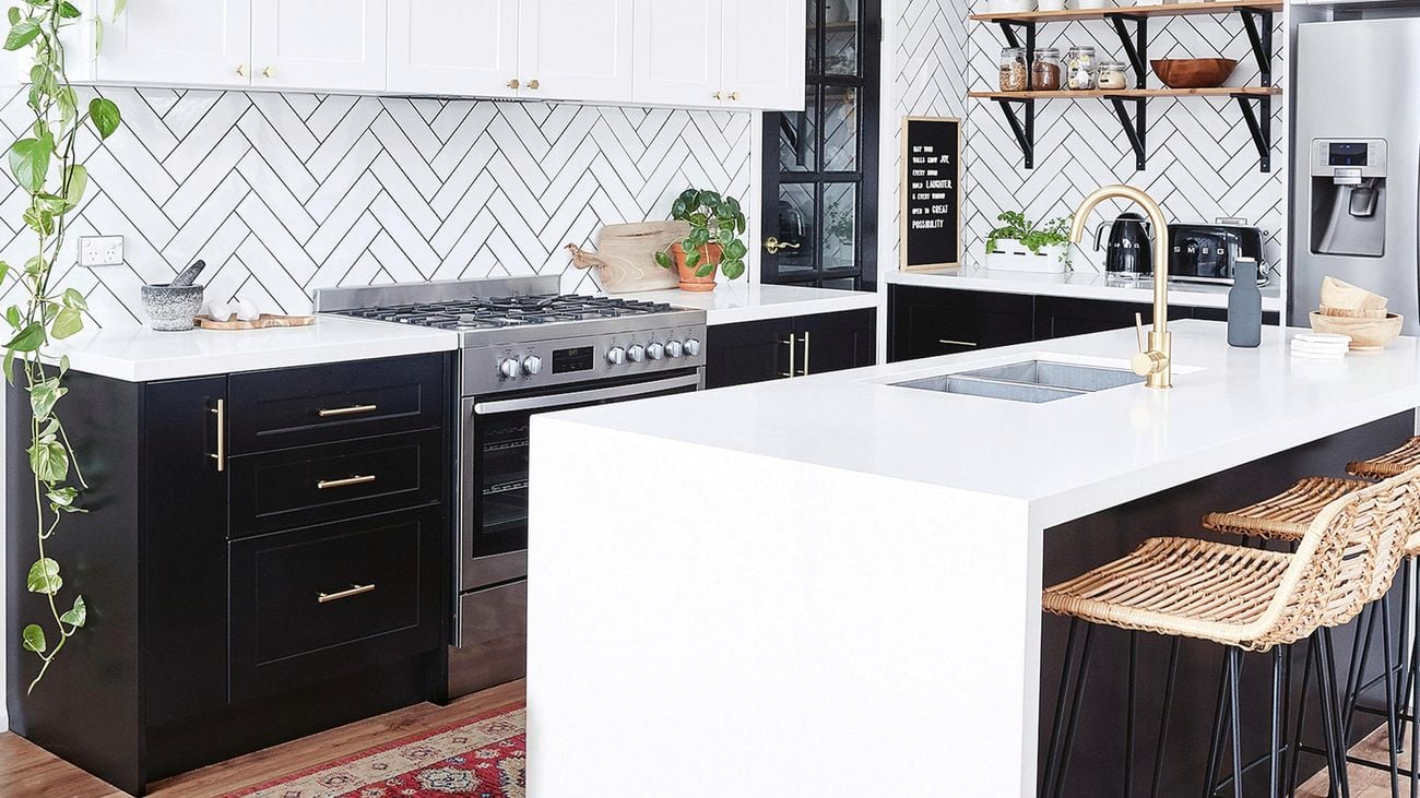 Black and white kitchen with brass accessories, handles and tapware.