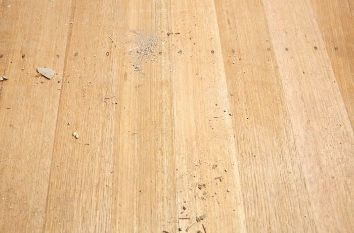 A hardwood timber floor covered with dust and debris