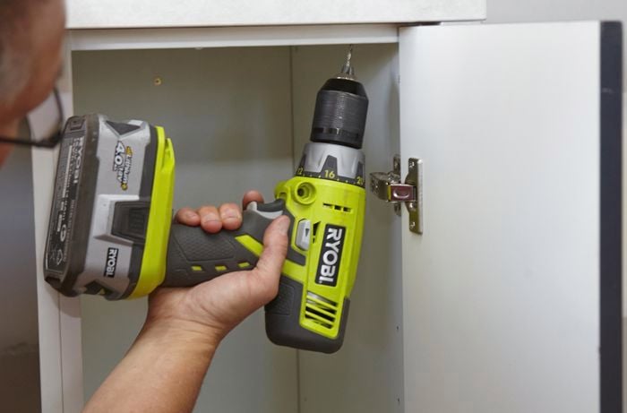 Person screwing benchtop and cabinet together
