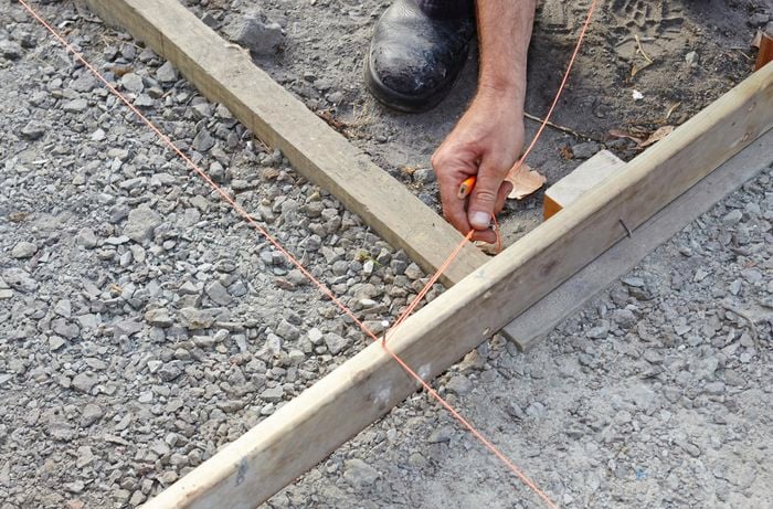 Person wrapping string around timber.