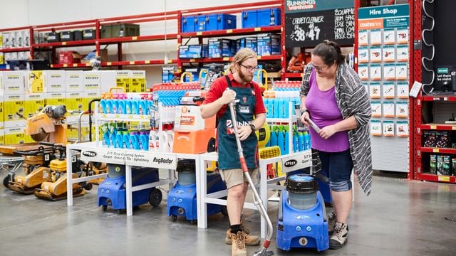 A Bunnings team member with a carpet cleaner helping a customer.