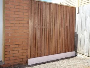 Timber screen in a backyard next to wooden fencing.