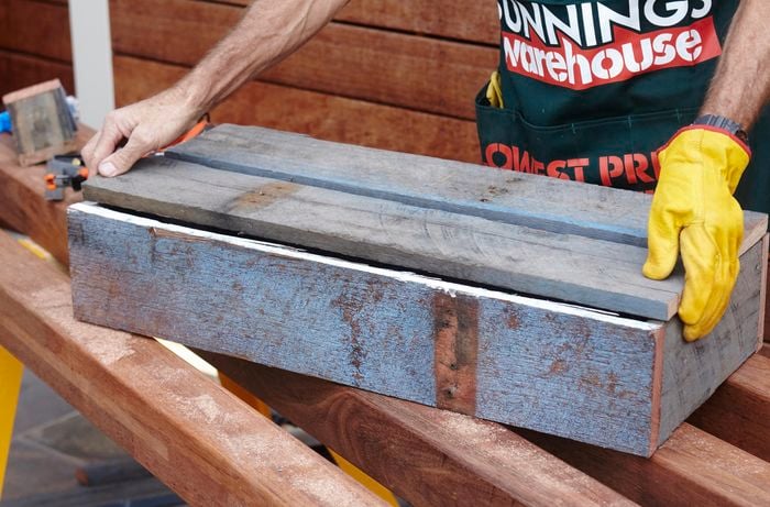 The base of a planter box being put into place by a Bunnings team member