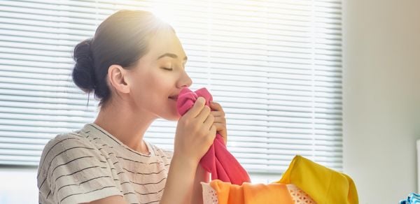Background banner image displaying person smelling the freshness of clothes