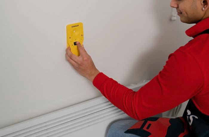 Stud finder used to look for a stud on the wall