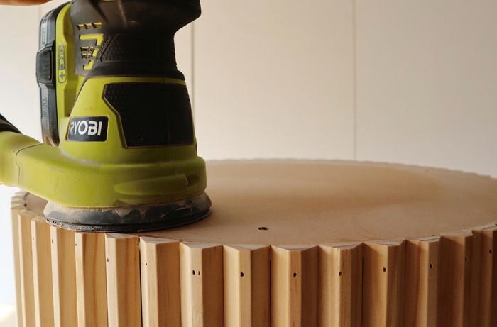 Person using sander to sand tabletop