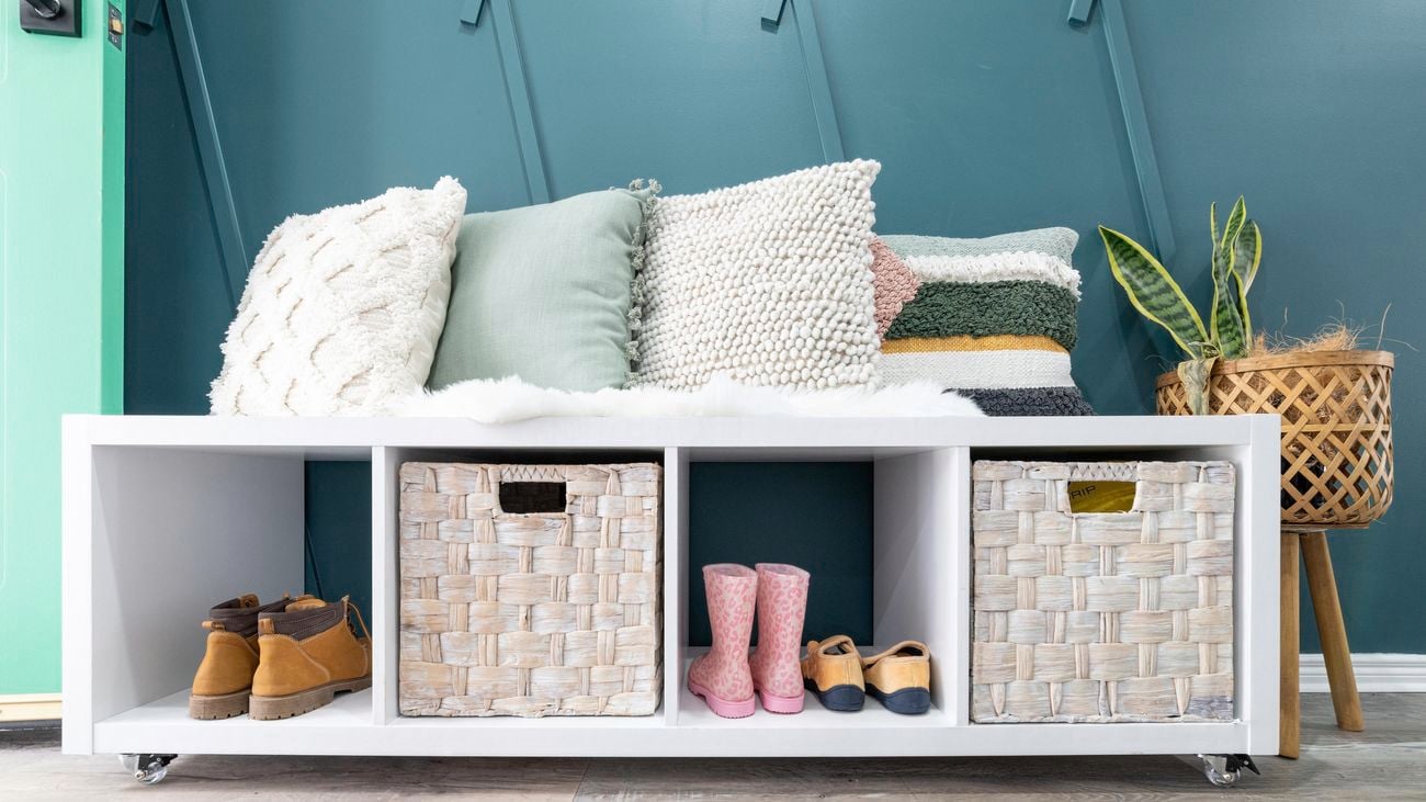 Storage cube bench seat with shoes and baskets in cavities beneath.