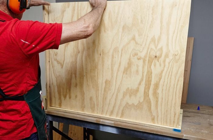 Person connecting pieces of ply panel using glue