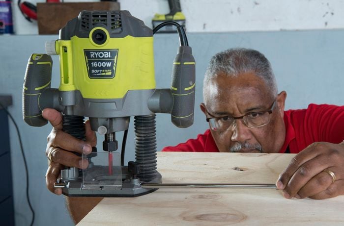 Person attaching router to center anchor point of timber