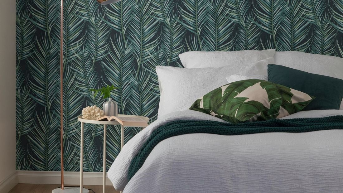 Forrest green leafy wallpaper in a bedroom.