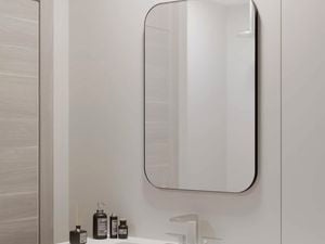A rectangular bathroom mirror with rounded corners