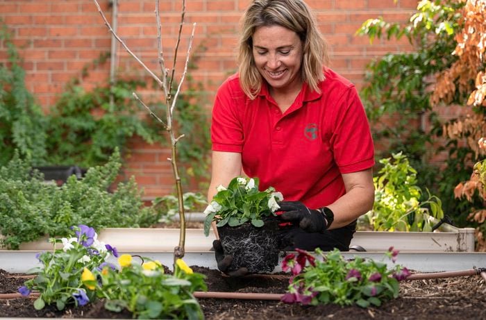 A woman holding a plant.