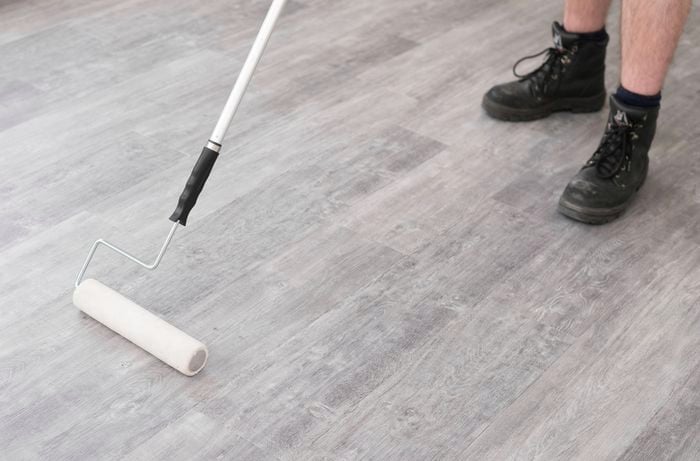 Applying pressure to set the plank with a floor roller. 