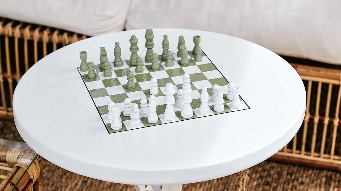 White coffee table with a chess board sitting top