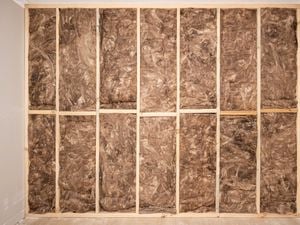 Insulation batts neatly installed between the wooden cavity