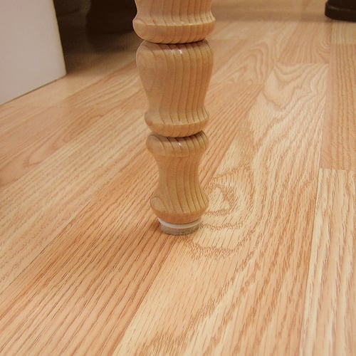Table leg with adhesive floor protection