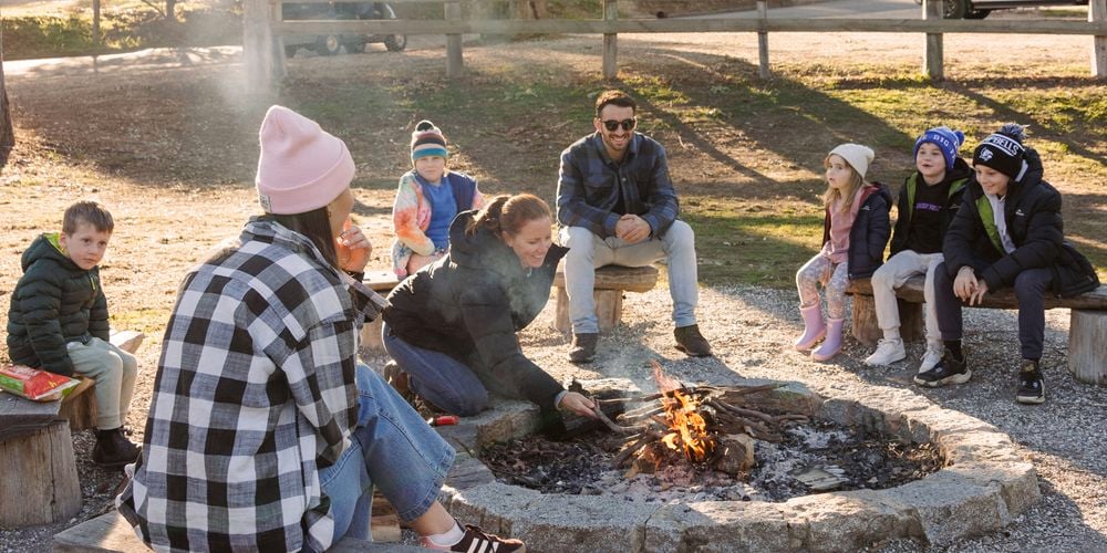 Friends
  and family gathered around communal fireput at a caravan park (3180823)