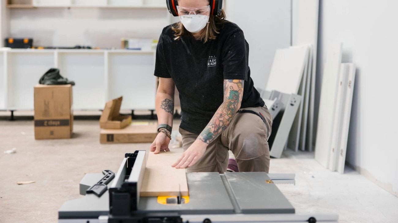 A female tradesperson uses the DeWALT table saw on an indoor job site