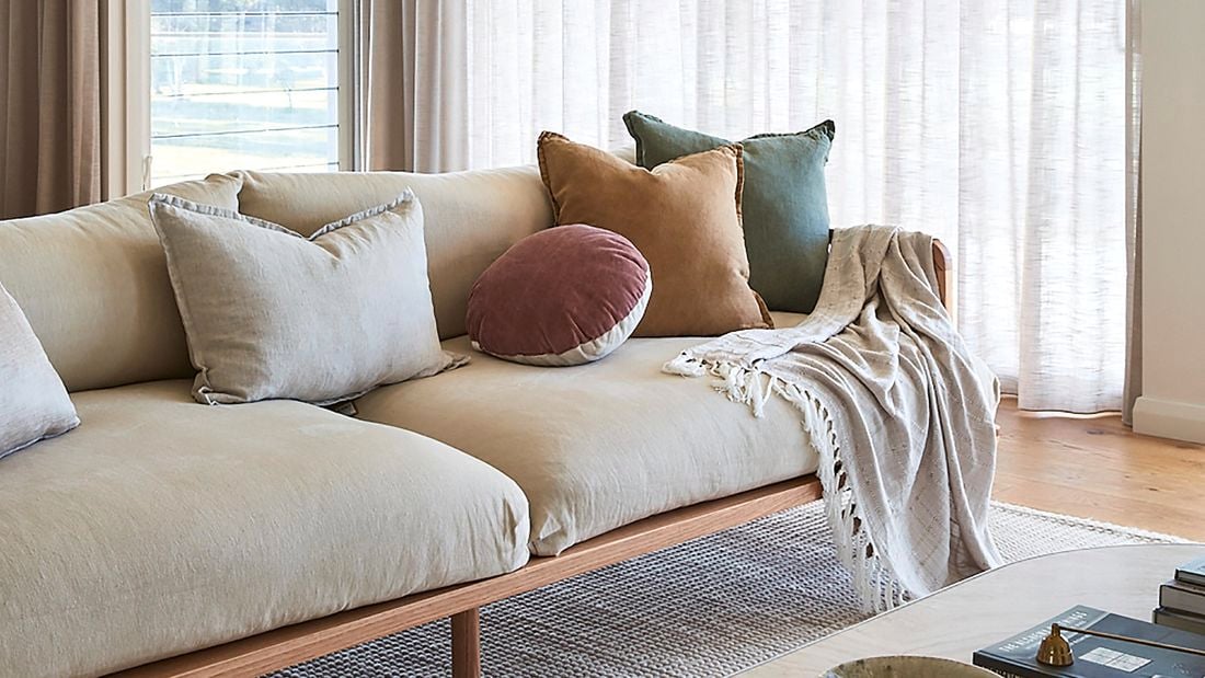 Lounge room with table, couch, carpet and curtains